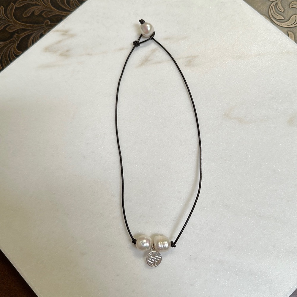 Costume jewelry: black cord with pearls and charm